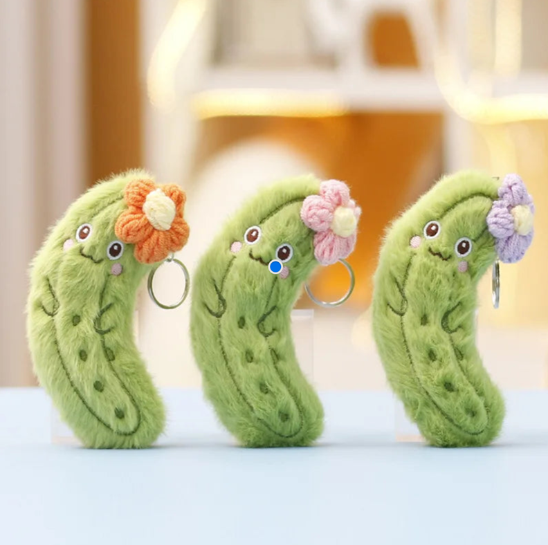three pickle keychains each with either a red, pink, or purple flower.